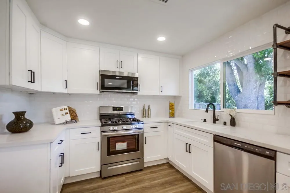 9841 Settle Road Santee, CA 92071 - Photo 25 of 46 a kitchen with a sink white cabinets and white appliances