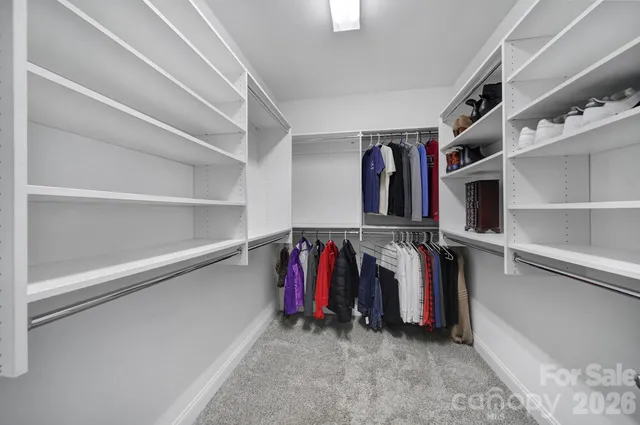 a view of walk in closet with clothes and shoes