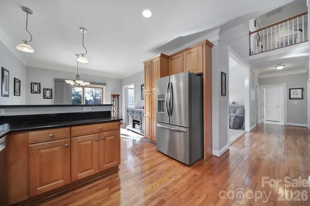 a kitchen with stainless steel appliances granite countertop a refrigerator a sink and a stove