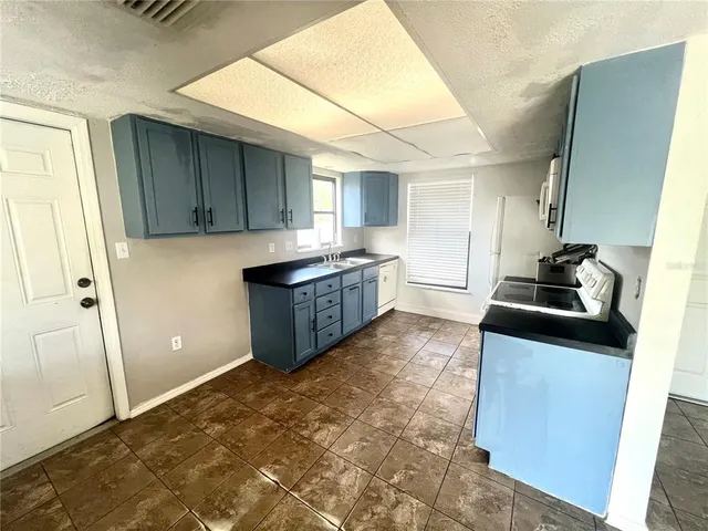 a kitchen with granite countertop a sink and cabinets