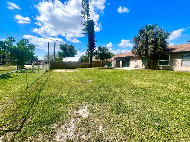 a view of a house with a big yard and potted plants