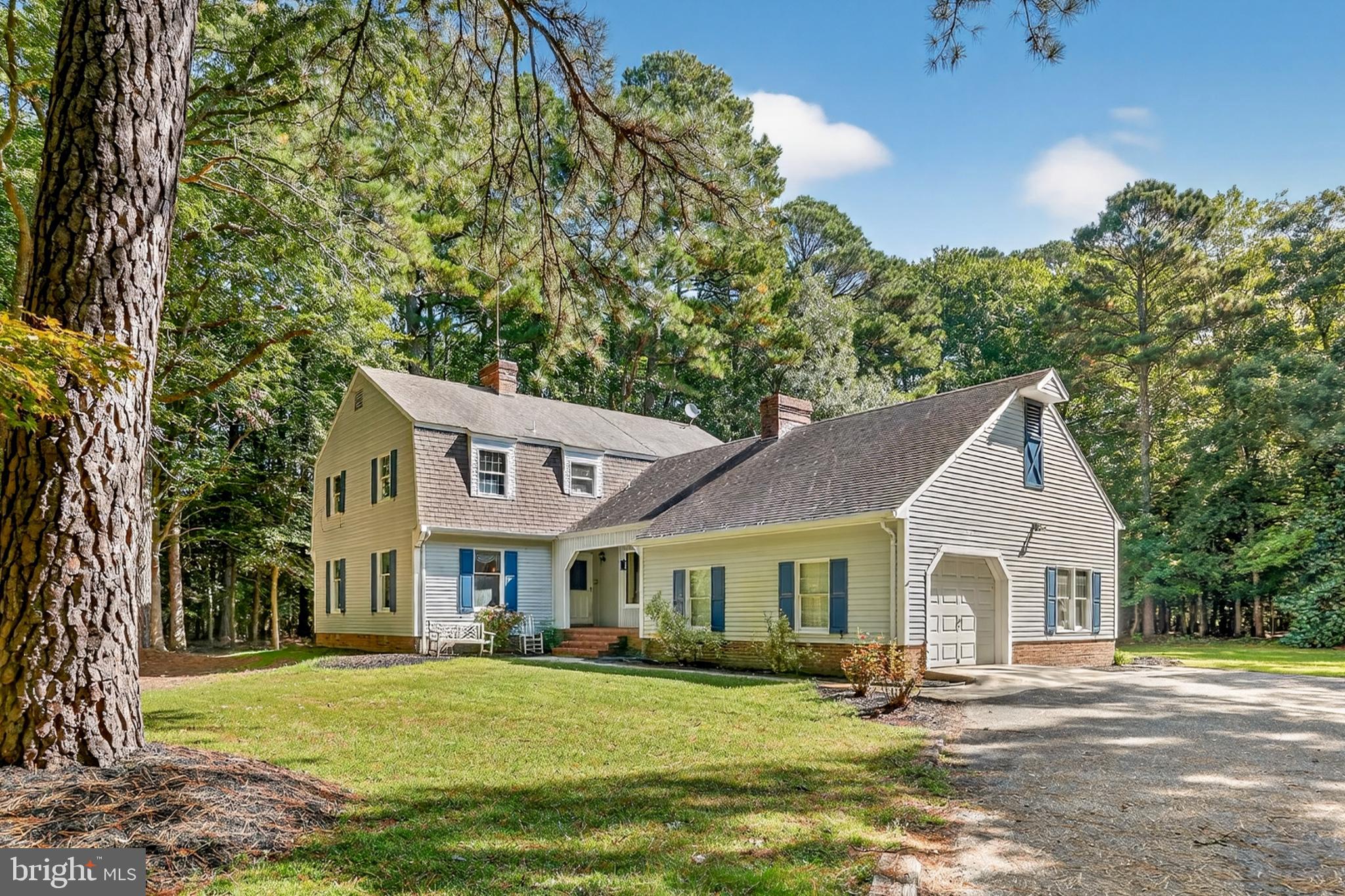 a front view of a house with a garden and trees