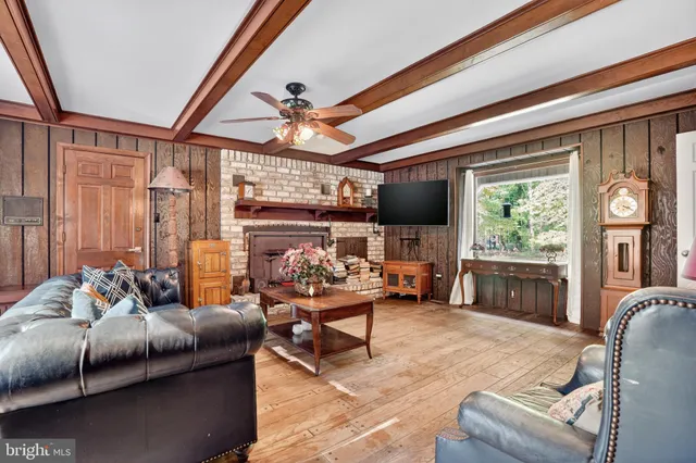 a living room with furniture a flat screen tv and a large window