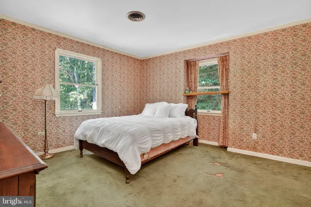 a bed sitting in a spacious bedroom next to a window