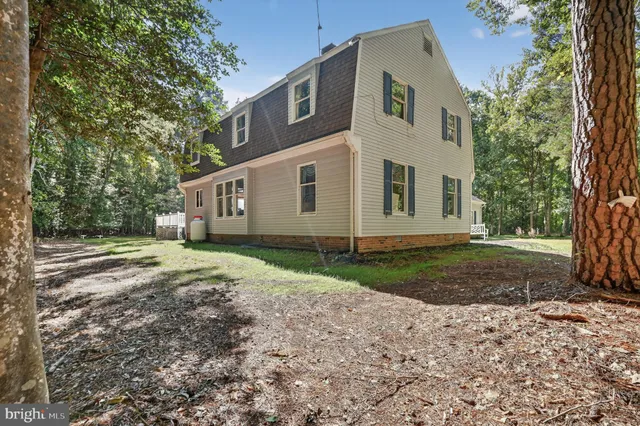 a view of a house with backyard and trees