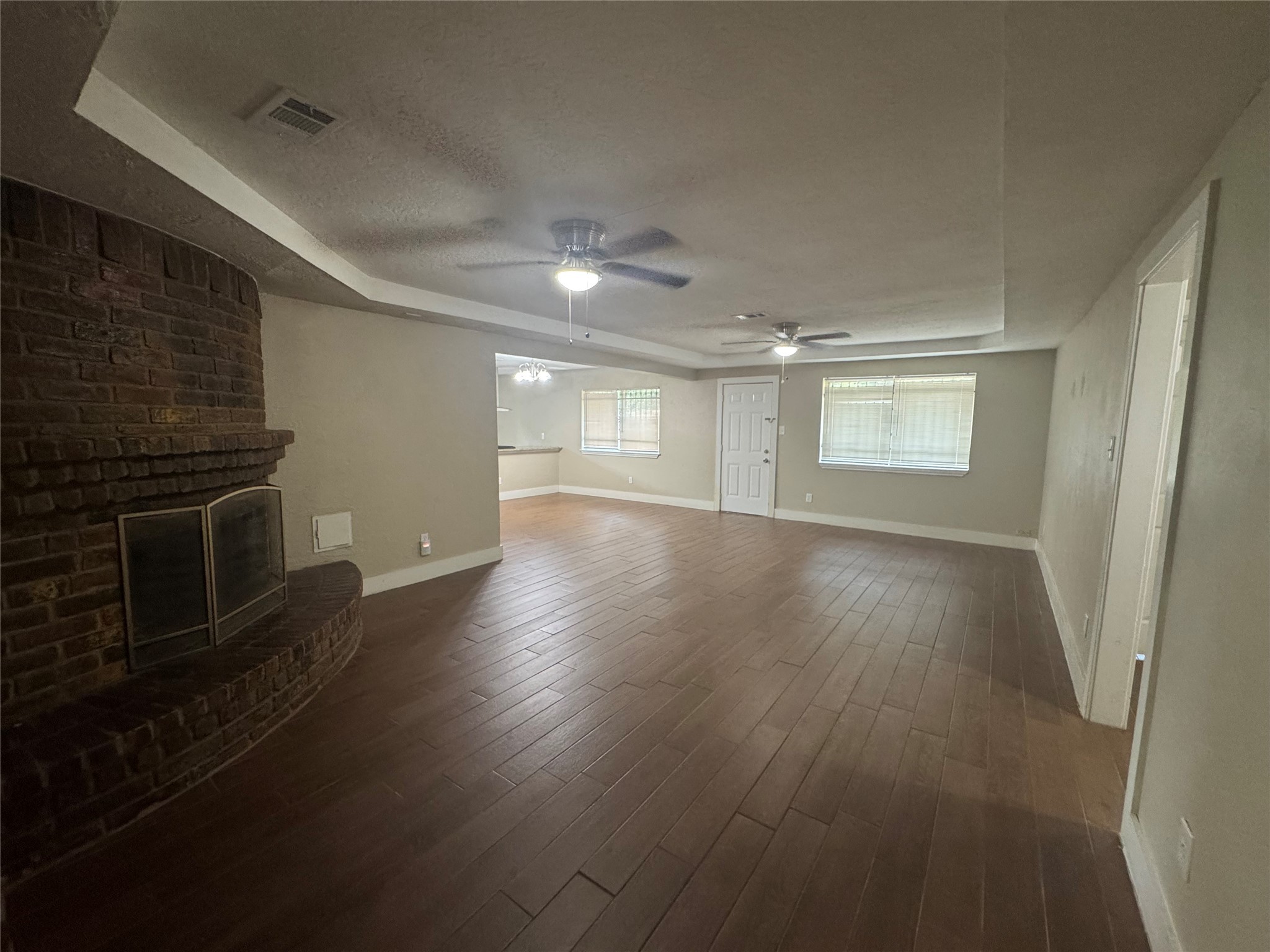 12811 Labelle Lane Houston, TX 77015 - Photo 2 of 14 an empty room with wooden floor fireplace and windows