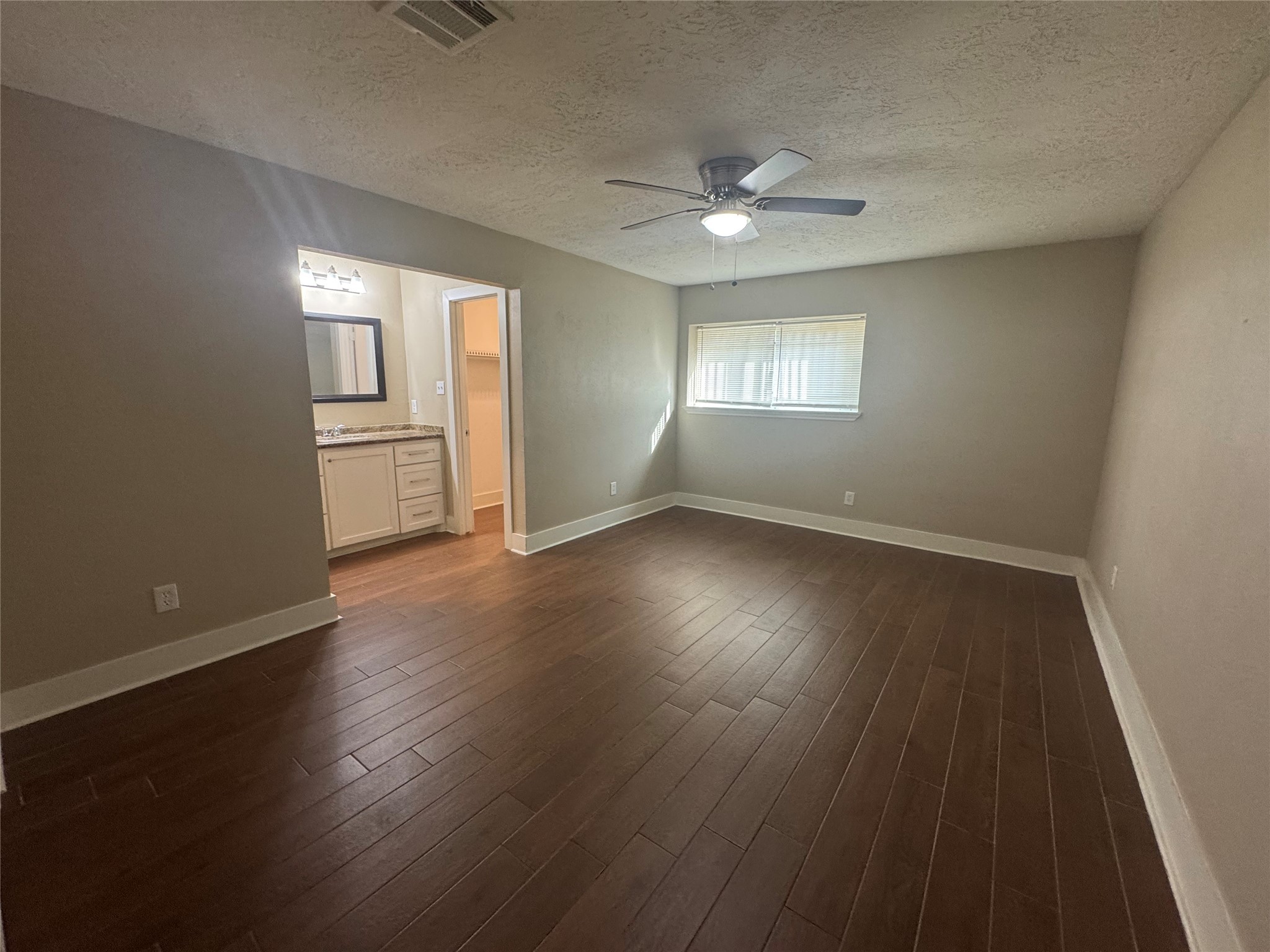 12811 Labelle Lane Houston, TX 77015 - Photo 7 of 14 an empty room with wooden floor chandelier fan and windows