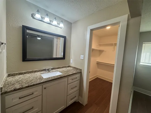 a bathroom with a granite countertop sink vanity and mirror