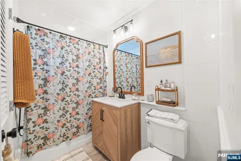 a bathroom with a sink toilet vanity and shower