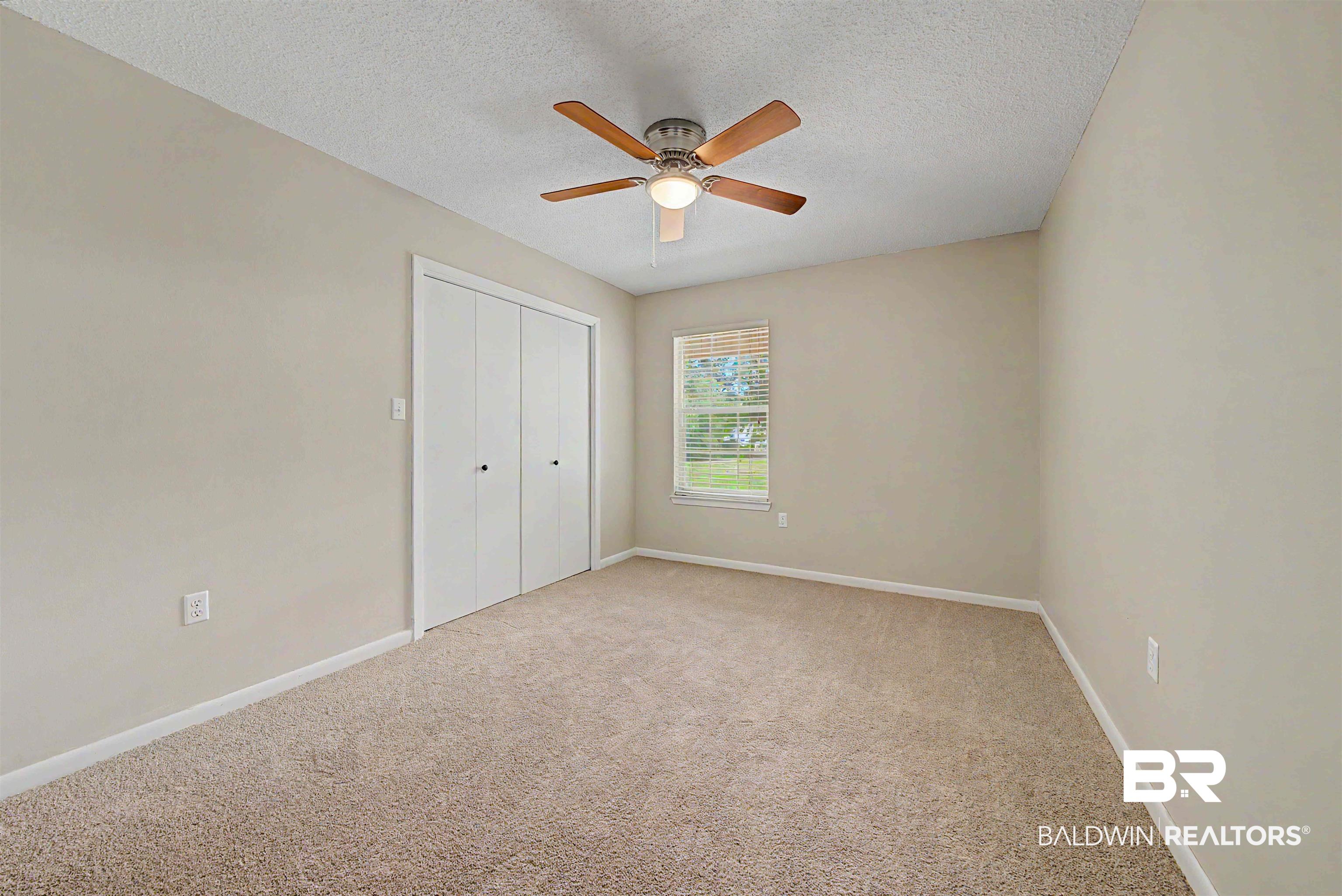 22963 Highway 98 Foley, AL 36535 - Photo 23 of 52 Carpeted room with a ceiling fan light fixture, a window with blinds, and bi-fold closet doors