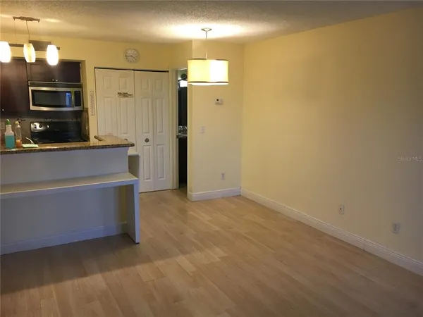 a view of an empty room with a kitchen