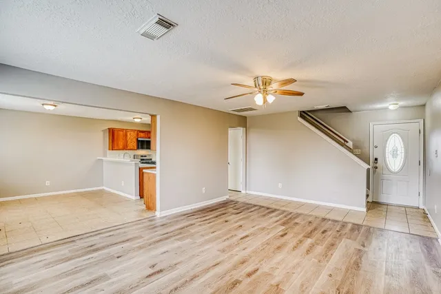 a view of a livingroom with wooden floor and a ceiling fan