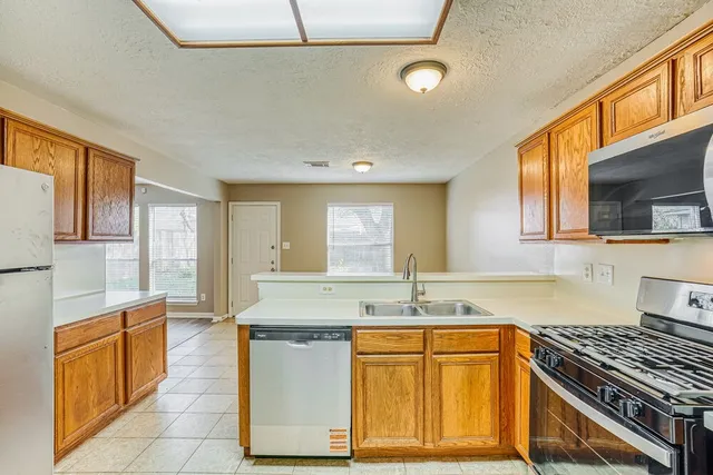 a kitchen with granite countertop a sink and a stove top oven