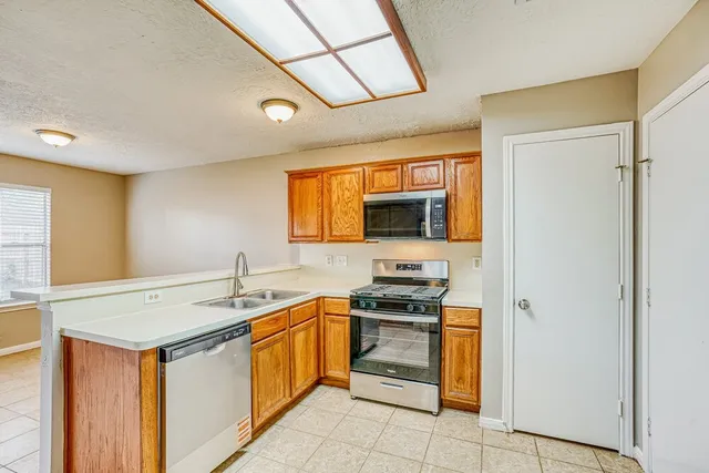 a kitchen with stainless steel appliances a stove sink and microwave