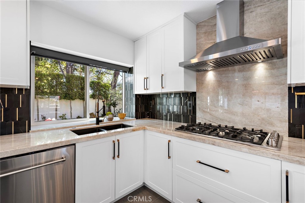 11 Bayside Irvine, CA 92614 - Photo 13 of 37 a kitchen with a stove a sink and a counter top space