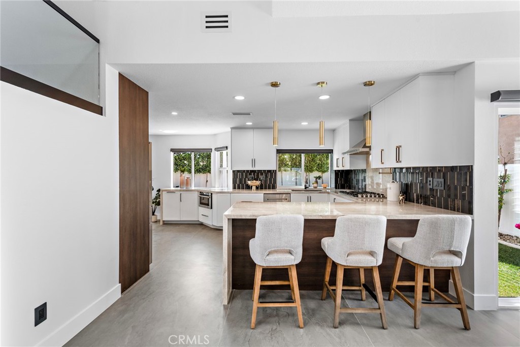 11 Bayside Irvine, CA 92614 - Photo 10 of 37 a kitchen with a dining table chairs wooden floor and appliances