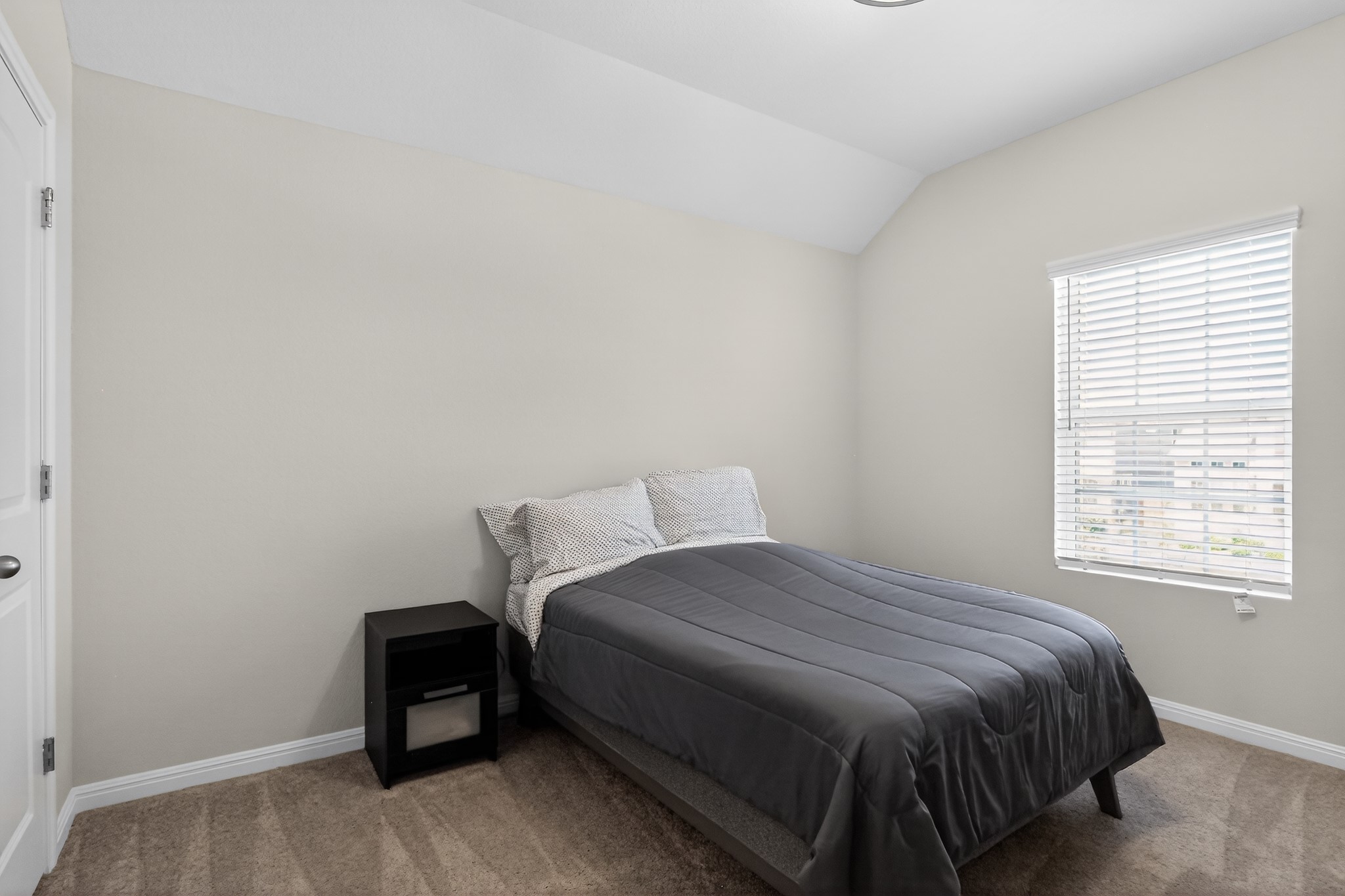 114 Bosco Road Hutto, TX 78634 - Photo 19 of 39 An inviting bedroom features a cozy bed, ample natural light, and plush carpeting.