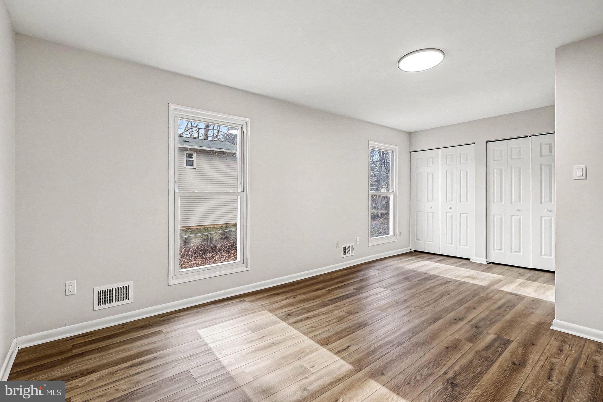 6214 Garretson Street Burke, VA 22015 - Photo 14 of 27 a view of an empty room with wooden floor and a window