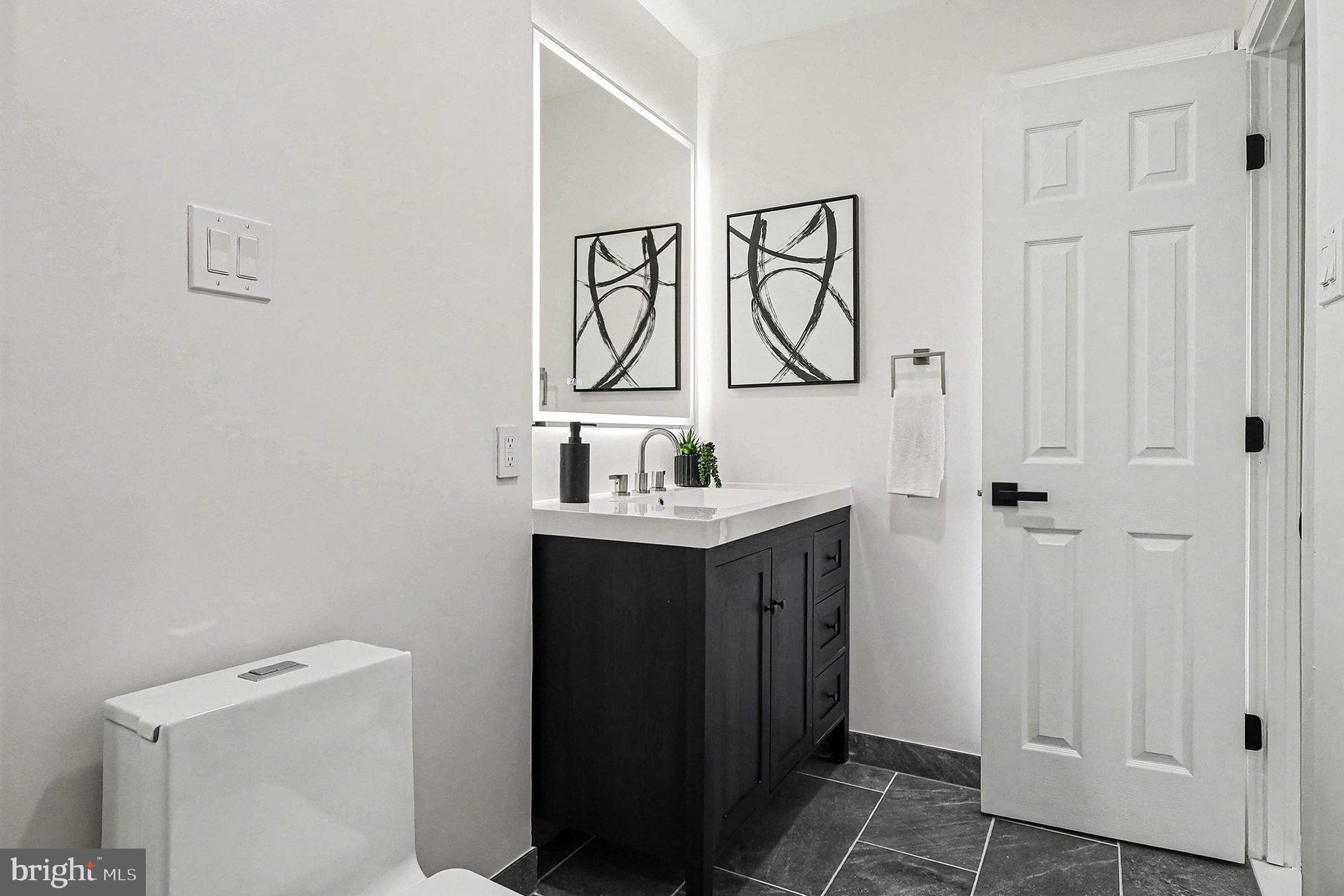 6214 Garretson Street Burke, VA 22015 - Photo 16 of 27 a bathroom with a sink and a mirror