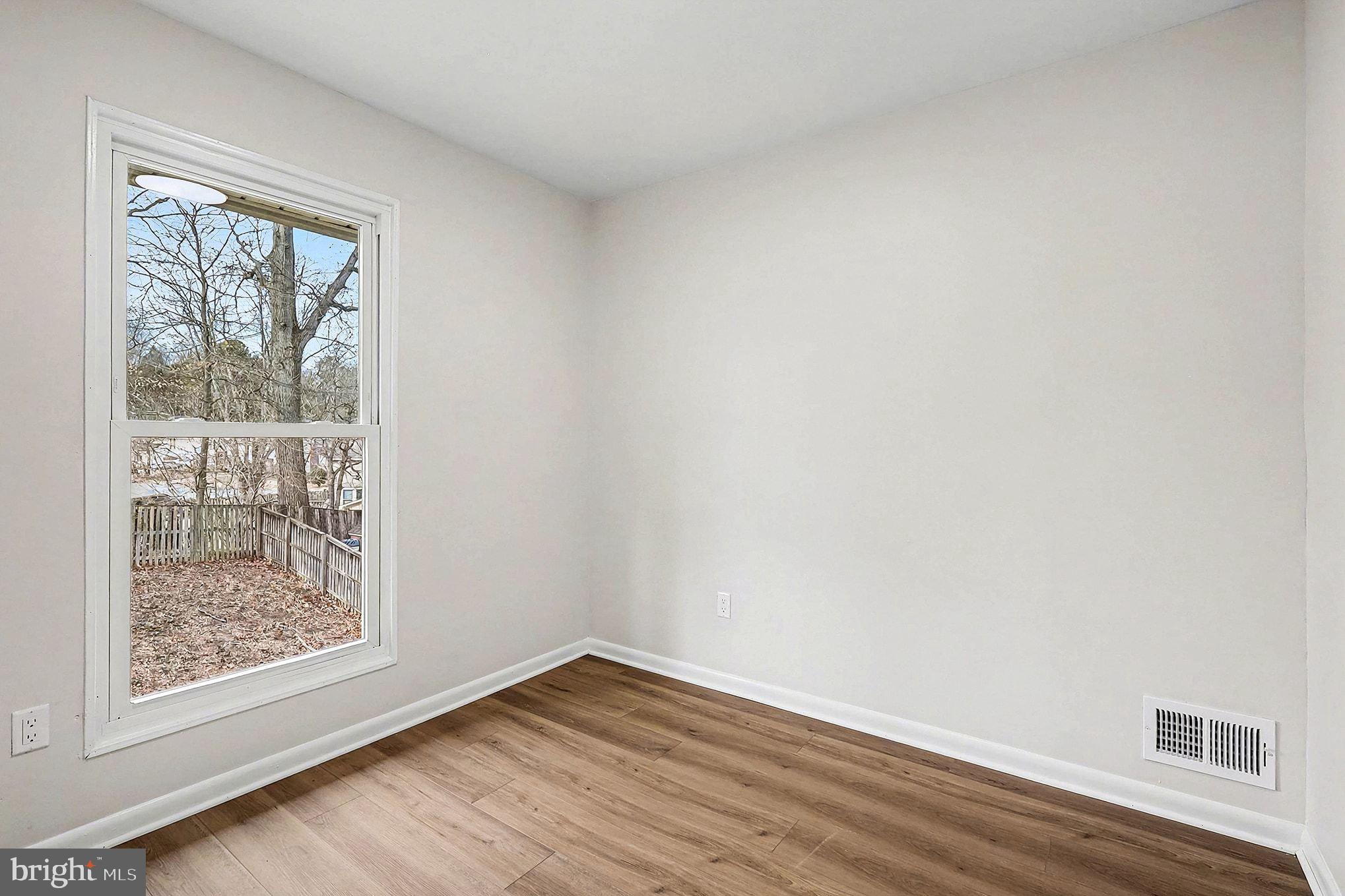 6214 Garretson Street Burke, VA 22015 - Photo 19 of 27 a view of an empty room with wooden floor and a window