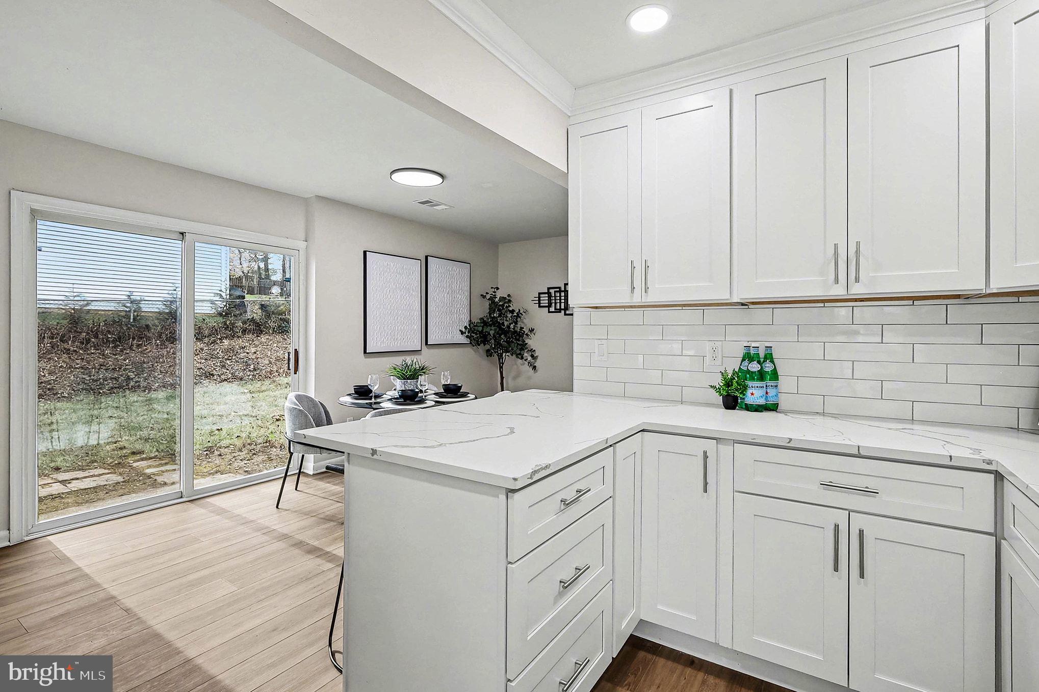 6214 Garretson Street Burke, VA 22015 - Photo 6 of 27 a kitchen with white cabinets and white appliances