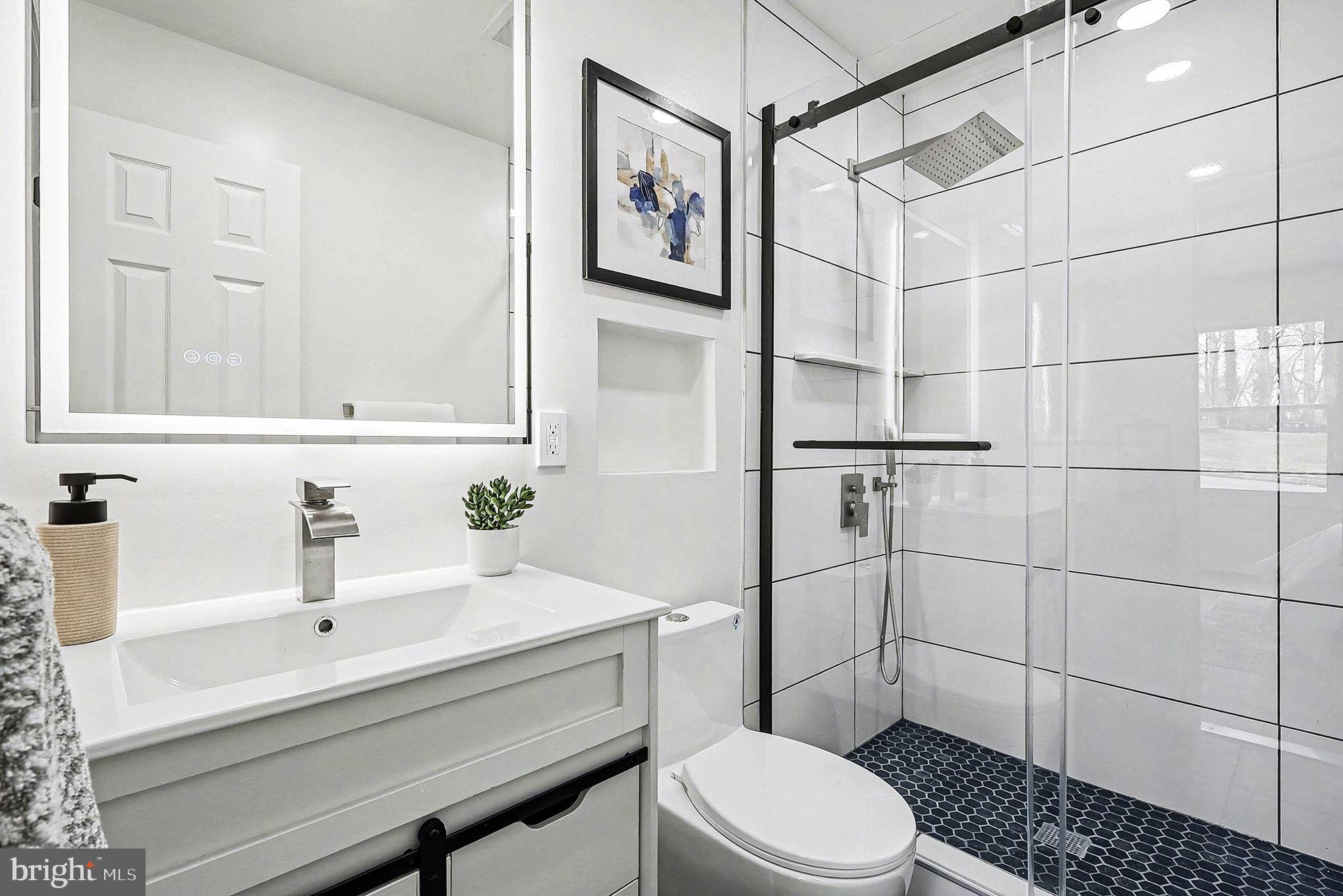 6214 Garretson Street Burke, VA 22015 - Photo 10 of 27 a bathroom with a sink toilet and shower