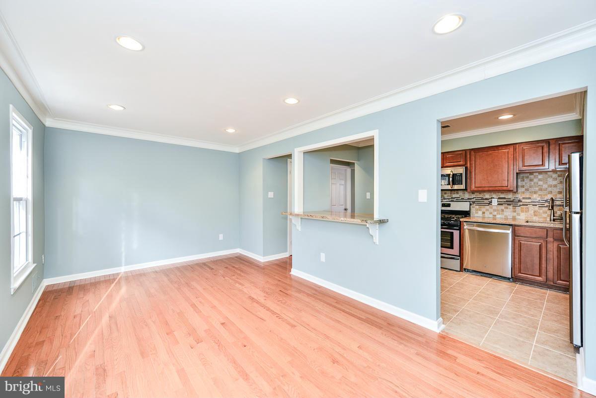 2407 Alsop Court Reston, VA 20191 - Photo 15 of 30 a view of a kitchen with kitchen island a sink wooden floor and stainless steel appliances