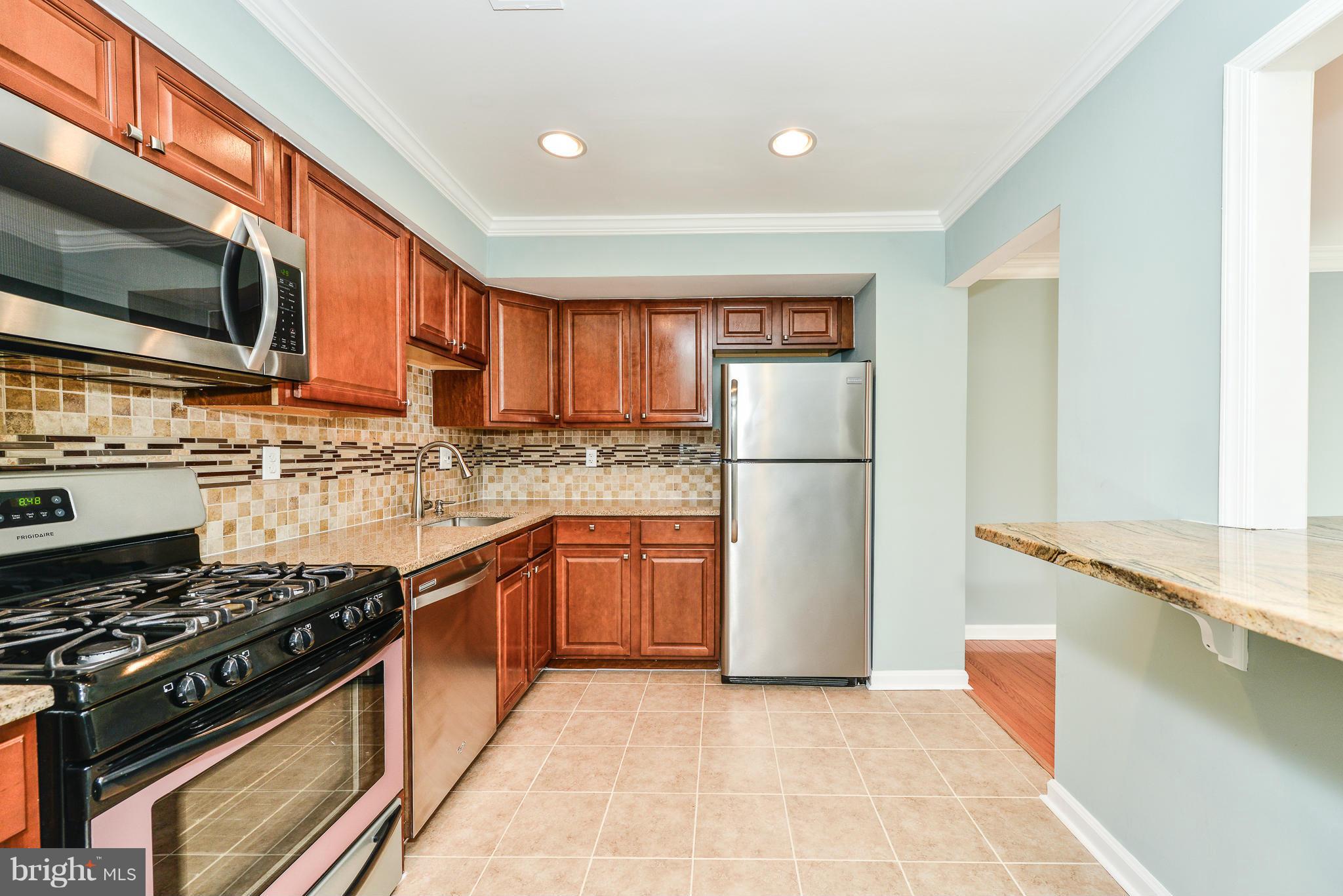 2407 Alsop Court Reston, VA 20191 - Photo 3 of 30 a kitchen with stainless steel appliances granite countertop a stove a refrigerator and a stove top oven