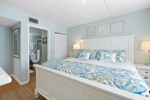 a bedroom with a large bed and a wooden floor