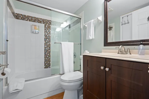 a bathroom with a sink a toilet and shower