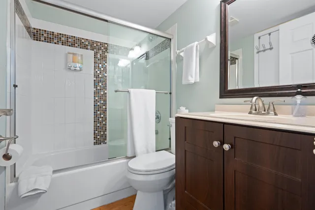 a bathroom with a sink a toilet and shower