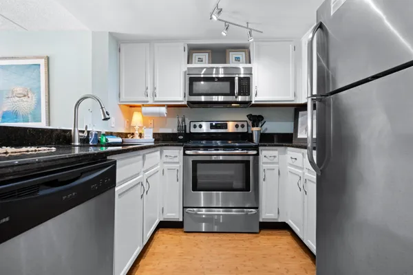 a kitchen with stainless steel appliances granite countertop a stove a refrigerator and a microwave