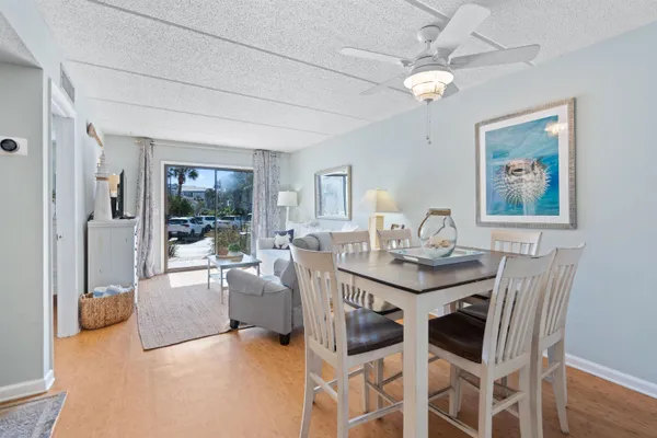 a view of a dining room with furniture a chandelier and wooden floor