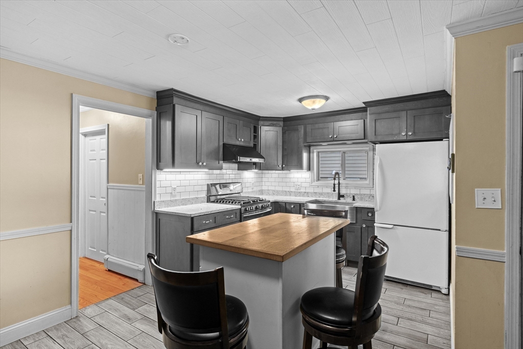 116 Weare Street Lawrence, MA 01843 - Photo 2 of 25 a kitchen with stainless steel appliances a refrigerator a sink a stove and cabinets