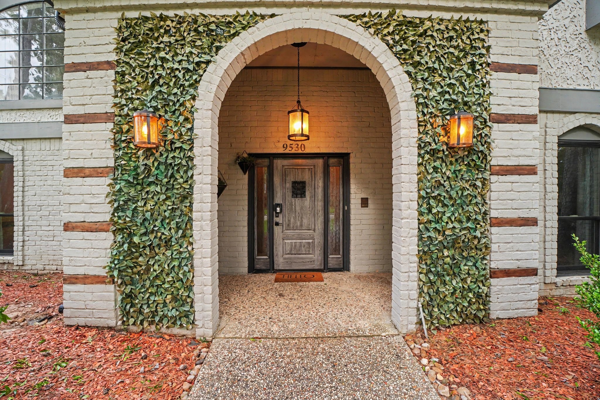 9530 Arcade Drive Spring, TX 77379 - Photo 4 of 32 Beautiful covered entry with an arched brick porch and decorative faux ivy accents, designed for curb appeal while remaining FHA and VA friendly with no maintenance concerns.