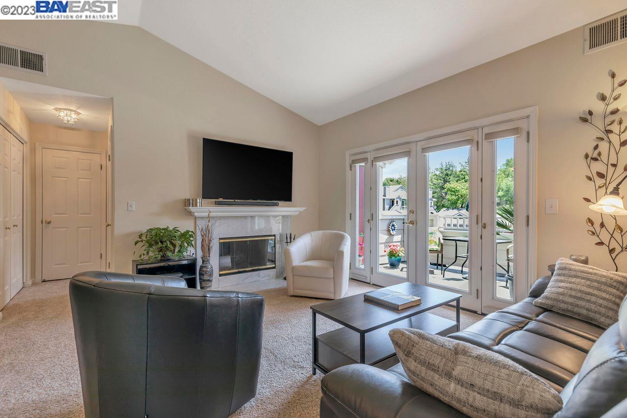 a living room with furniture a fireplace and a flat screen tv