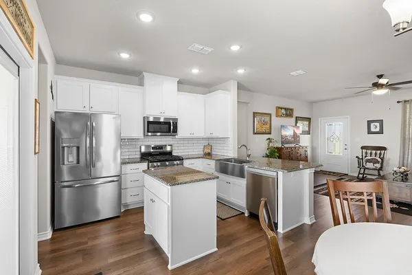 a kitchen with white cabinets and stainless steel appliances