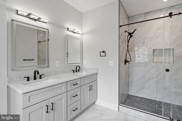 a bathroom with a double vanity sink mirror double and shower