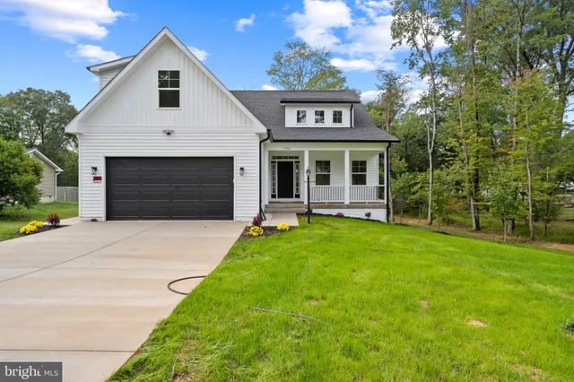 a front view of a house with a garden and yard