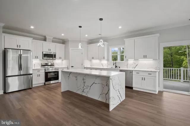 a large white kitchen with a stove a sink dishwasher a refrigerator and white cabinets with wooden floor