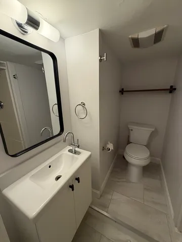 a bathroom with a toilet sink and mirror