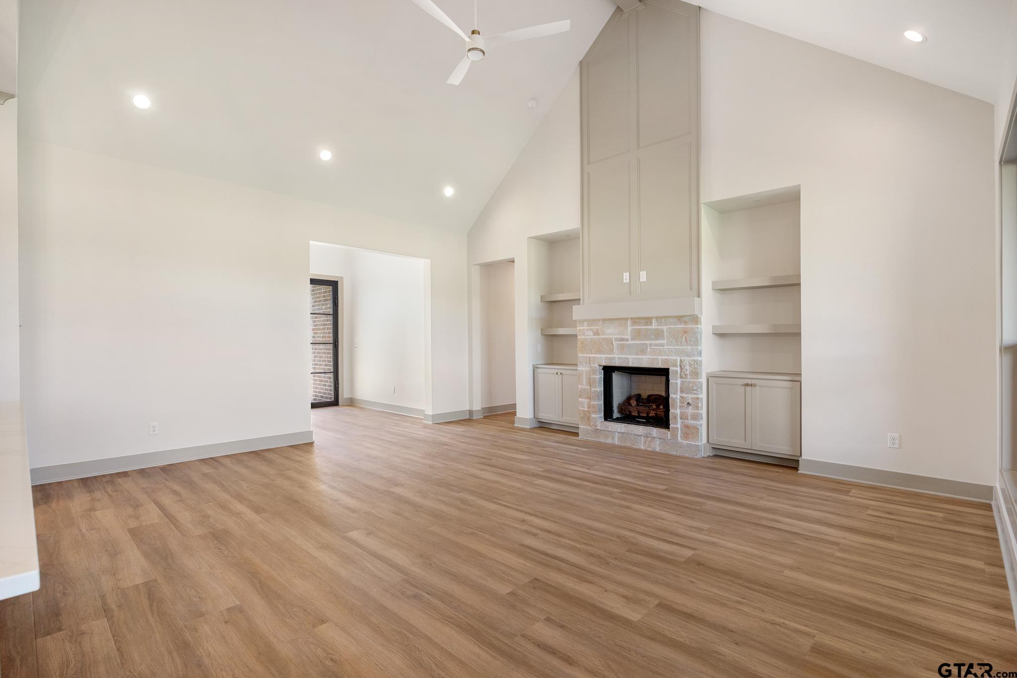 508 Artesian Meadow Drive Bullard, TX 75757 - Photo 12 of 46 an empty room with wooden floor fireplace and windows