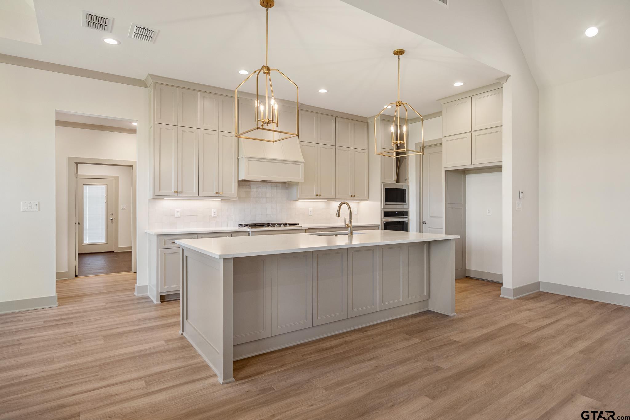 508 Artesian Meadow Drive Bullard, TX 75757 - Photo 14 of 46 a kitchen with kitchen island a counter top space a sink appliances and cabinets