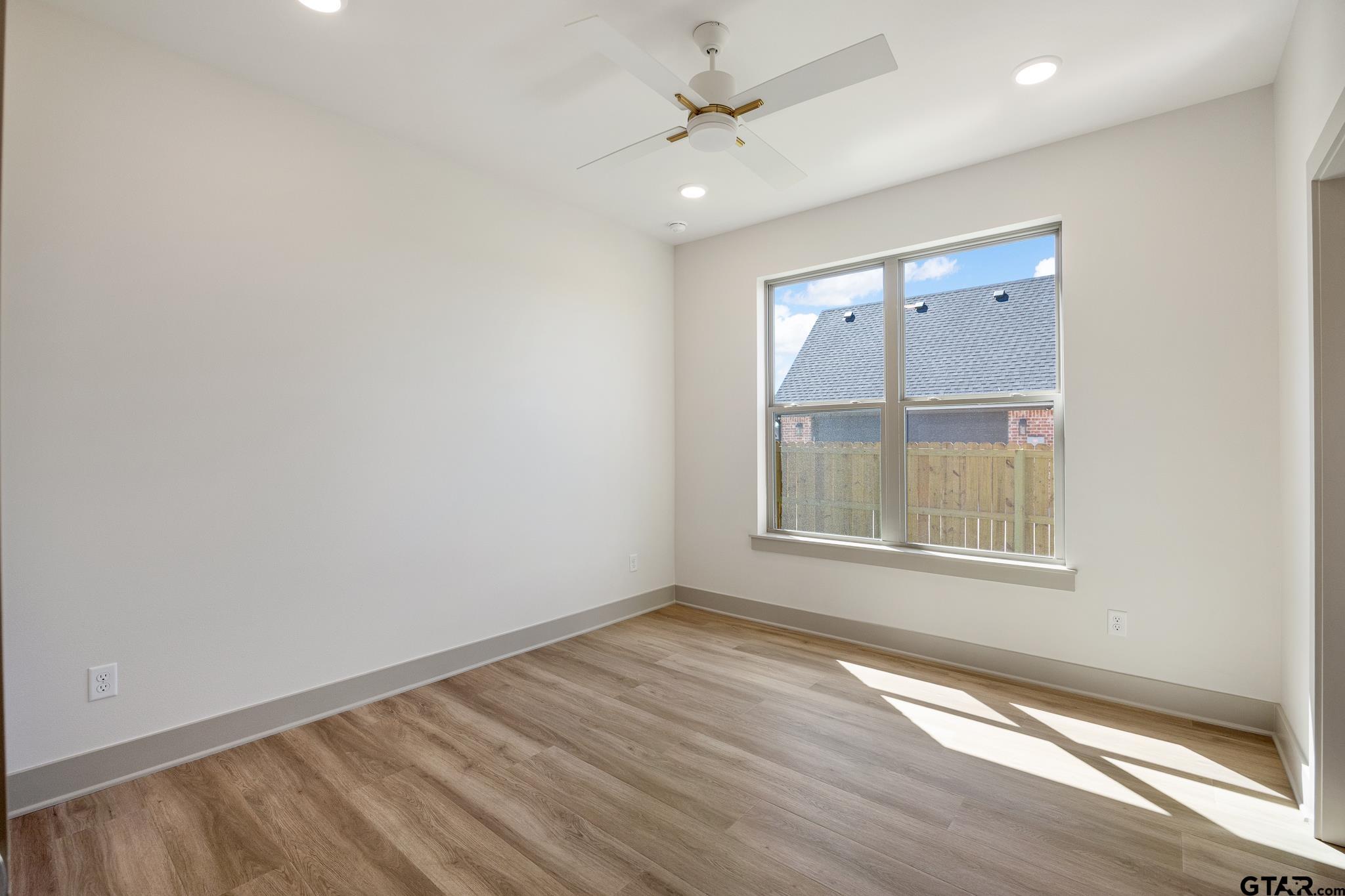 508 Artesian Meadow Drive Bullard, TX 75757 - Photo 35 of 46 an empty room with wooden floor ceiling fan and windows