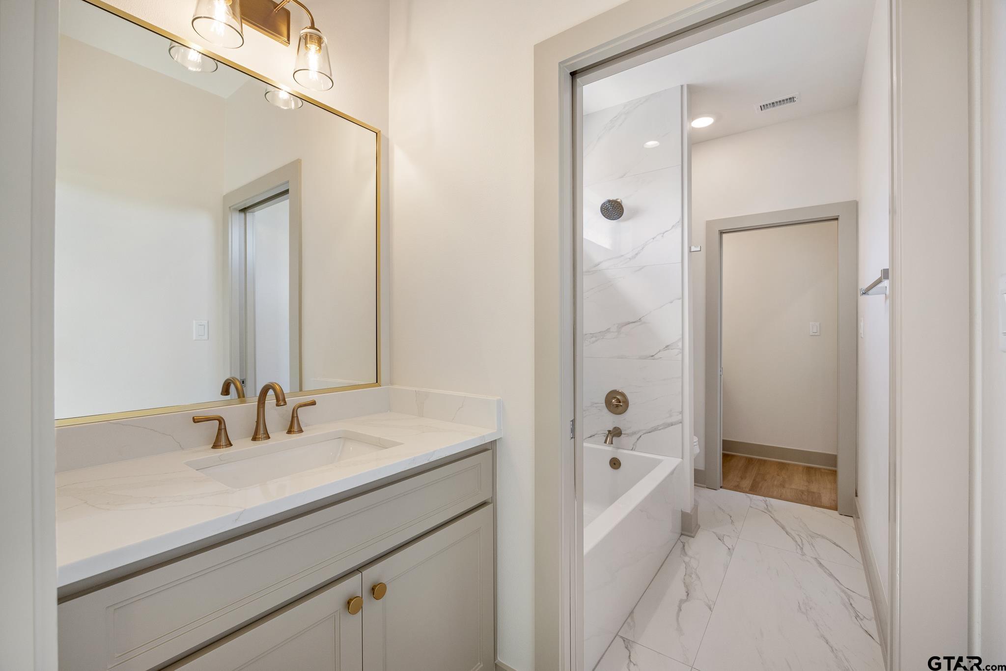 508 Artesian Meadow Drive Bullard, TX 75757 - Photo 36 of 46 a bathroom with a sink a tub and a mirror