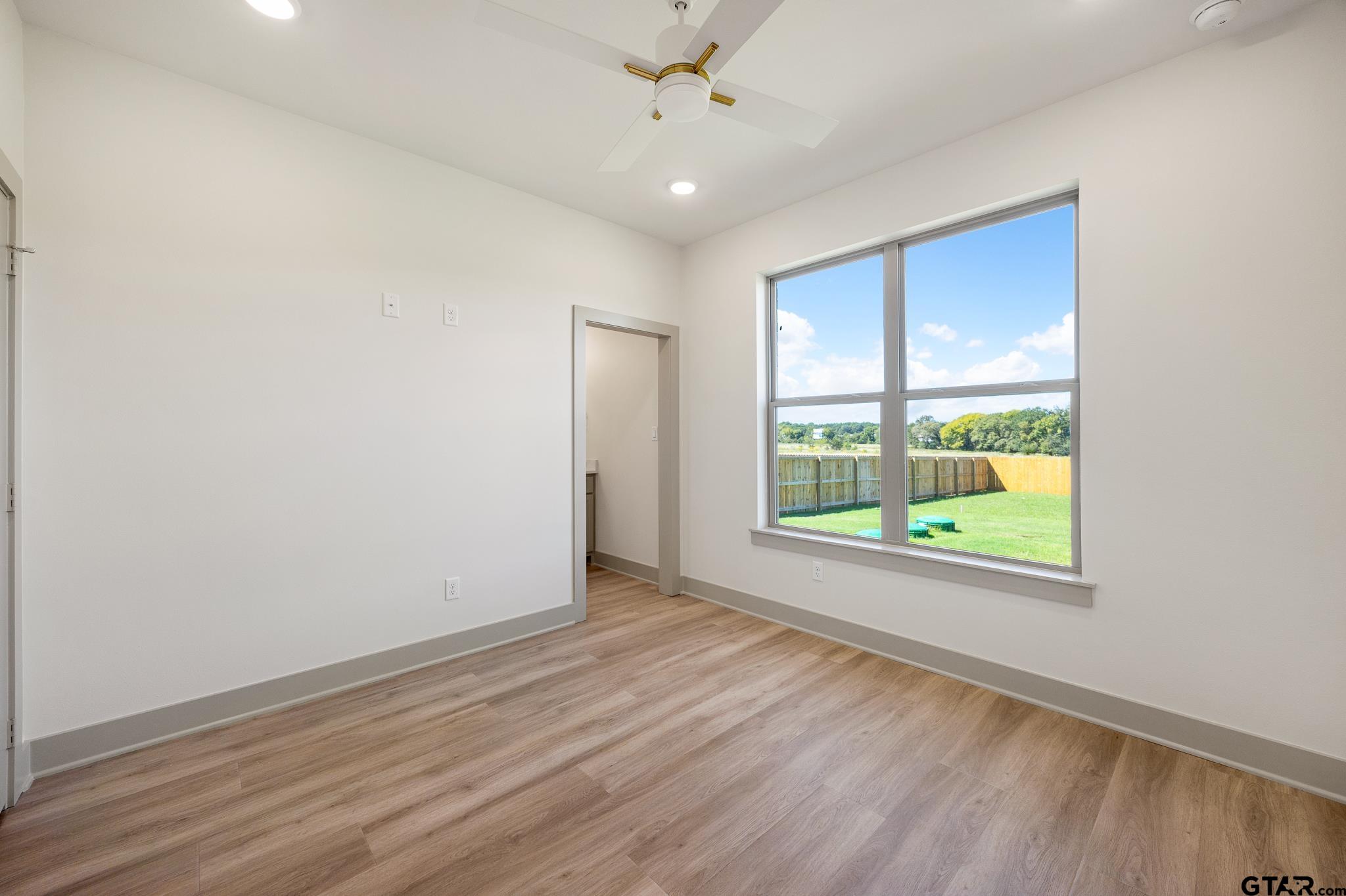 508 Artesian Meadow Drive Bullard, TX 75757 - Photo 39 of 46 an empty room with wooden floor chandelier fan and windows