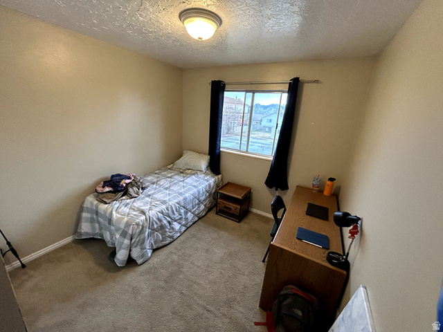 939 South Freedom Boulevard, Unit 13 Provo, UT 84601 - Photo 12 of 26 Carpeted bedroom featuring a textured ceiling and baseboards