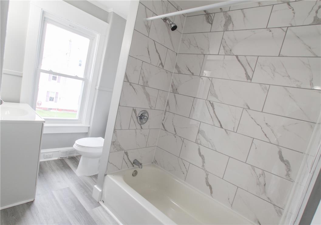 933 Philadelphia Road Easton, PA 18042 - Photo 17 of 23 Gleaming marble-patterned wall tiles enclose a classic shower and tub combination.