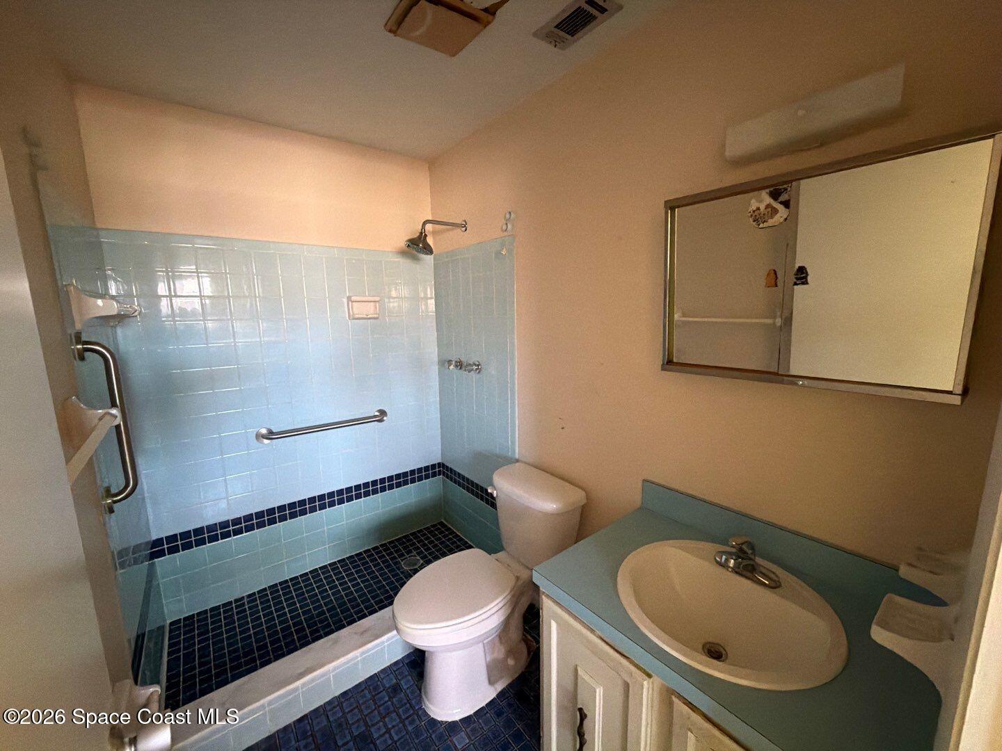 2972 Matthew Drive Rockledge, FL 32955 - Photo 18 of 24 a bathroom with a granite countertop toilet sink and mirror