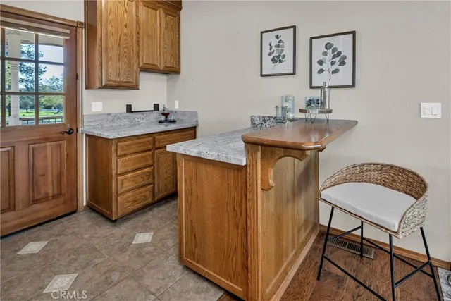 a kitchen with stainless steel appliances granite countertop a stove a sink a refrigerator dining table and chairs